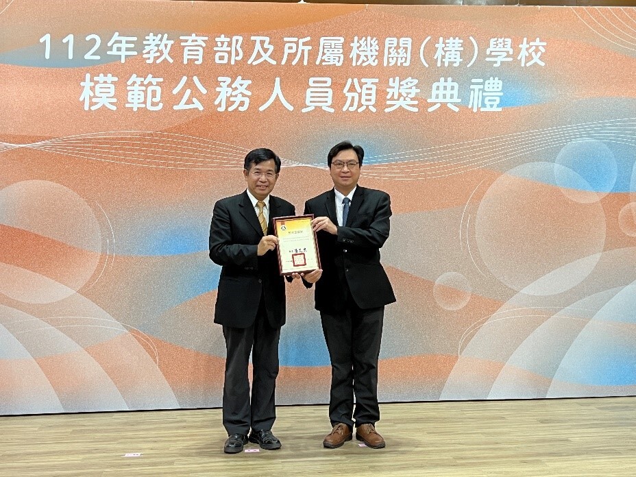 廖興國主任秘書（右）接受潘文忠部長（左）頒贈獎狀。