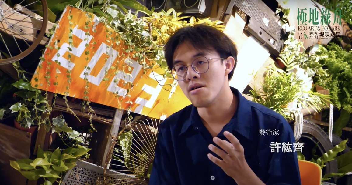 美術系學生許紘齊與其創作作品《綠洲(舟)》合影。