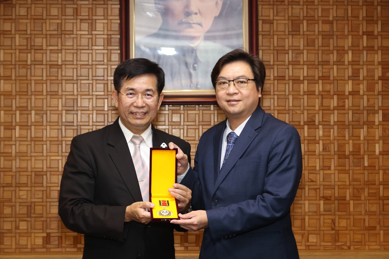教育部潘文忠部長（左）頒授廖興國主任秘書（右）二等教育專業獎章。