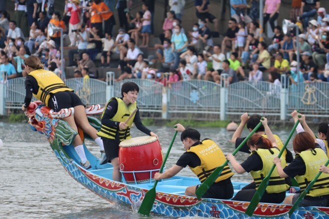 本校奪標手爬上龍頭準備奪旗。 NCUE’s flag catcher climbs onto the dragon head, ready to grab the flag.