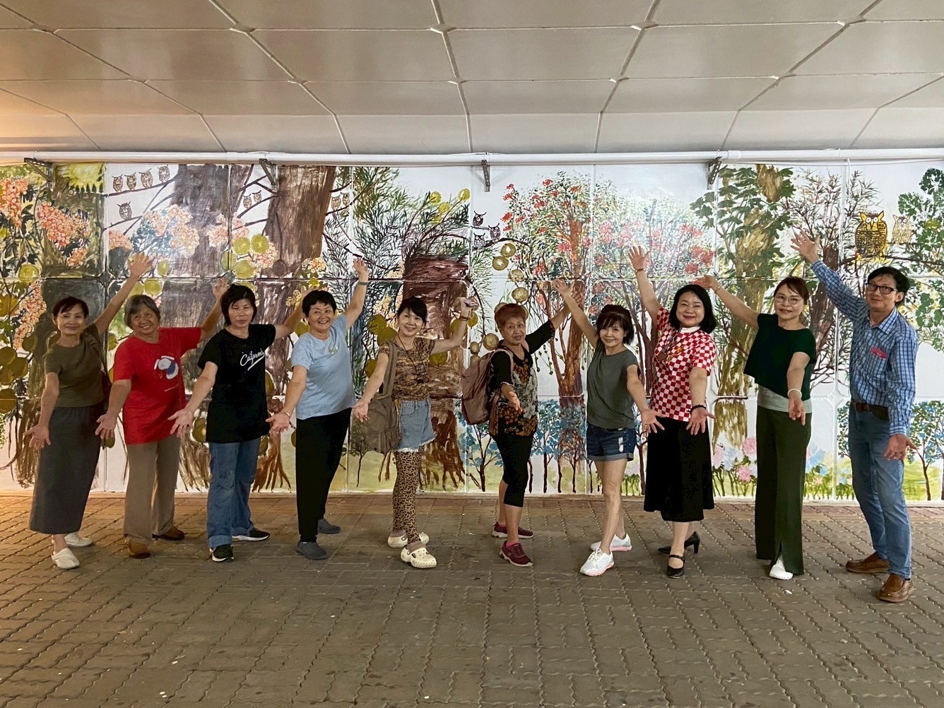 馬來西亞傑出校友莊永瑞老師（右）、大馬美術家協會朱紹瑛總會長（右五）及七位藝術家以「生命教育」為主題，分別於進德校區湖濱館五樓及寶山校區一處約30米的連結通共同揮灑畫筆，創作四幅充滿生命力與希望的壁畫。圖為藝術家們在寶山畫作前的合影。Mr. Yoon Sooi Chong (right), a distinguished Malaysian alumnus, joined eight artists from the Malaysian Artists Society (PPM), led by President Shirley Chu (fifth from right), to create vibrant murals with the theme “Life Edu-cation” on the 5th floor of NCUE’s Hu-Bin Building (Jinde Campus) and along a 30-meter passageway at Baoshan Campus, where they posed for a group photo in front of their mural.