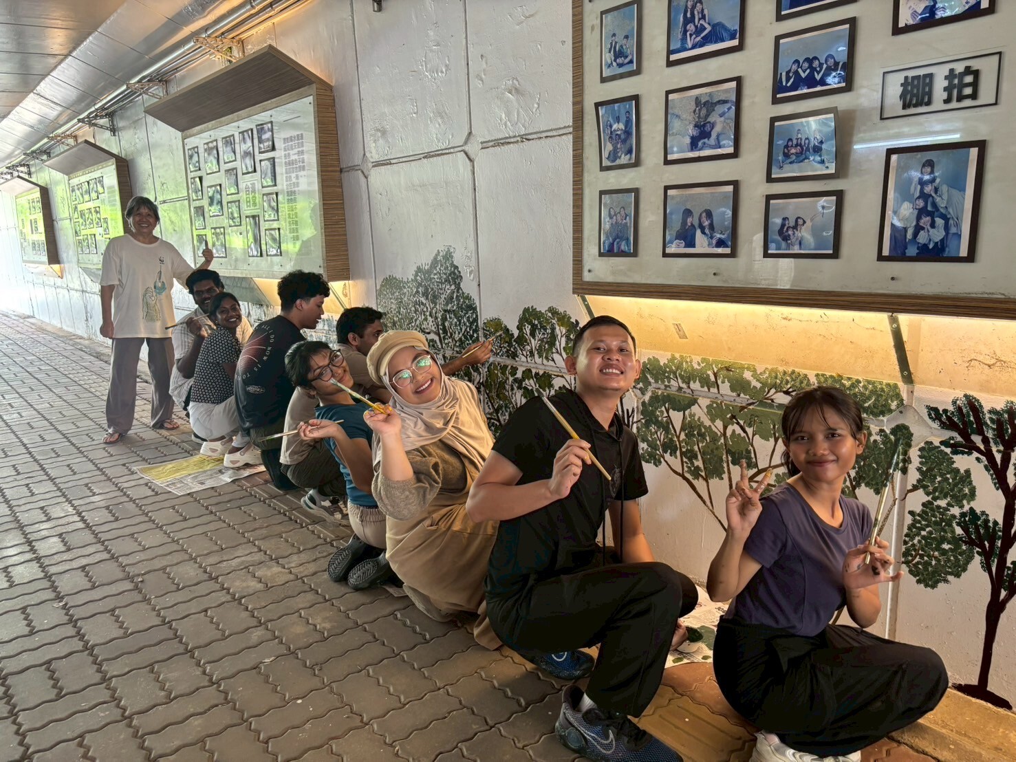 學生們成為壁畫活動的小幫手。Students assisted the artists during the mural work.