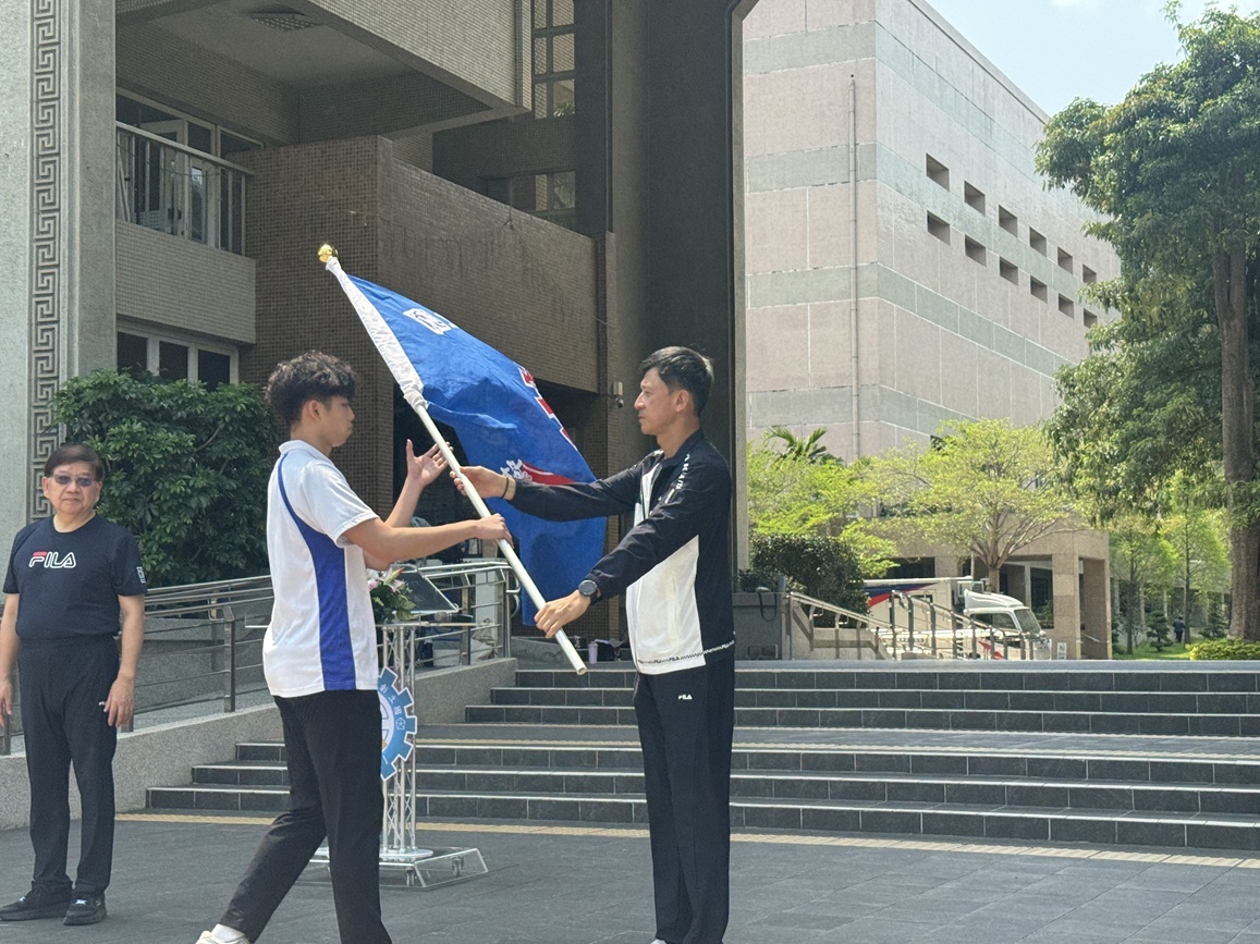 體育室江勁彥主任傳遞校旗給跆拳道代表隊何秉宸同學。