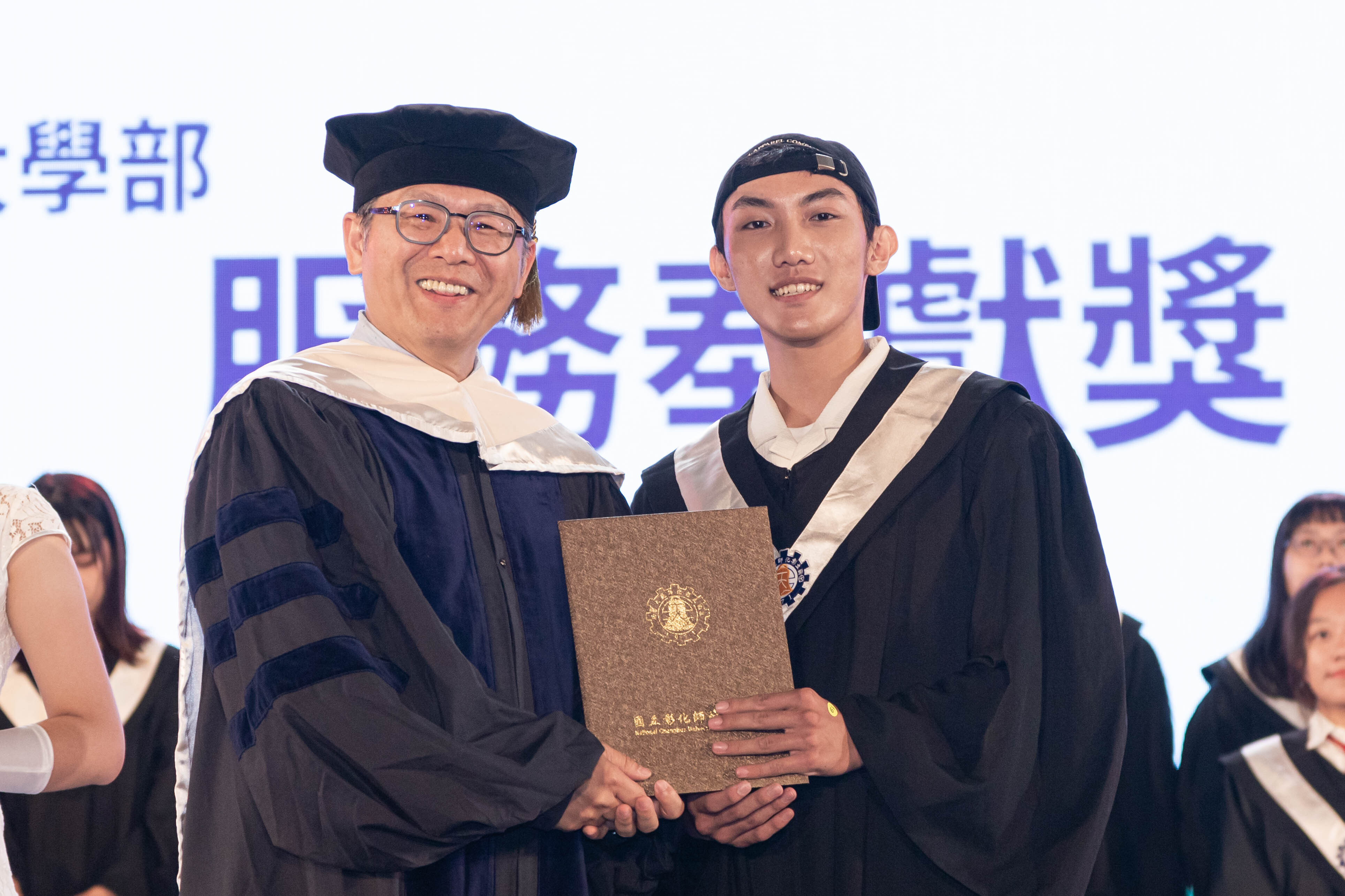 李宗信學務長頒發大學部服務奉獻獎予獲獎代表同學。